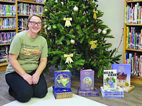 West End Public Library in industry also got books from Night Heron Media prior to Christmas. Shown with some of the donated titles is Monika Foltz, director and librarian.
