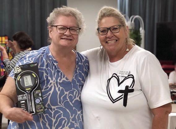 The blackout prize in a bingo game – a lighted magnifying glass – was won by Cathy Besetzny (left). Bingo was called by Deannie Crim (right) of Schulenburg Family Fitness Center.