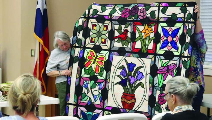 Brenda Jeschke (top photo, standing at left) spoke to the CVQG about what a judge looks for at a quilt show. She presented a quilt as an example of “what not to do” (top photo) and an example of a quilt with visual effects (bottom photo).