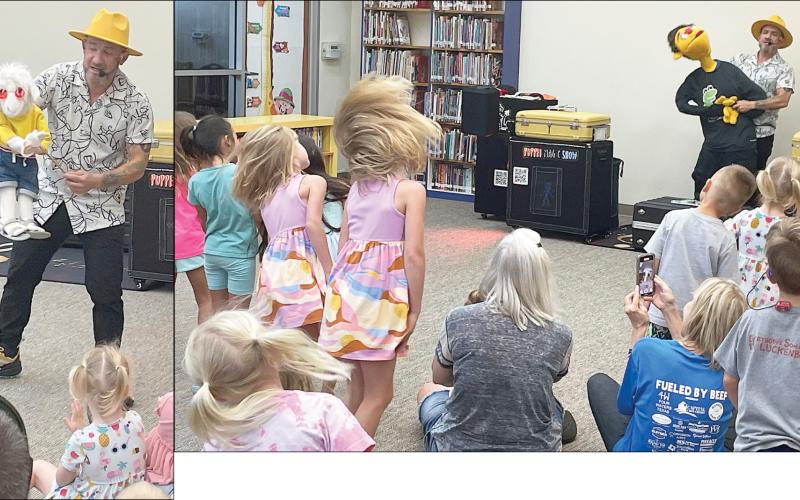 Puppeteer Mr. Leo and his cool goat (left) interact with youngsters after the children enjoyed a song and dance with him and his buddy, “Tommy” (above). The show last Friday morning was the first of the local public library’s Summer Reading Program that continues through late July. Sticker Photos By Darrell Vyvjala
