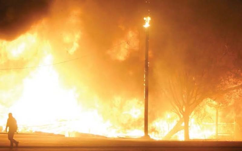 Fire fully engulfs the two homes to the east of Schulenburg Liquor Store near the intersection of Highway 90 and Highway 77. Sticker Photo By Darrell Vyvjala