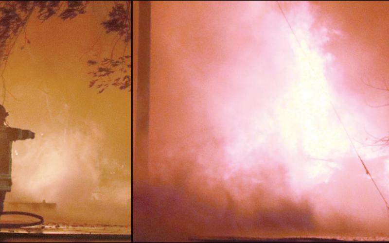 Firefighters work to knock down the flames on the south side of the blaze from Summit Street
