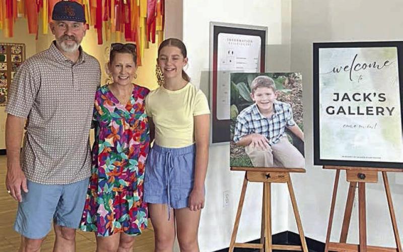 Turtle Wing Foundation was established in honor of Jack Hooper, son of Chris and DeeAnn Hooper. Jack, who had been diagnosed with high-functioning autism at age 6, passed away on April 5, 2011. Shown are (from left) Chris and DeeAnn Hooper and their daughter Cate Hooper. A portrait of Jack Hooper is placed between the family and the Jack’s Gallery sign.