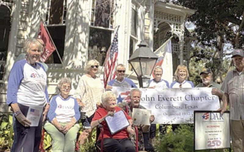 Bob and Nancy Stiles (front, holding certificates) feel that flying the American flag shows pride in this country. They also fly the Texas flag and the Columbus Cardinals flag. DAR/SAR representatives shown are (back row, from left) Judy Zachmeyer, Glen Strey (behind Zachmeyer), Nelma Strey, Connie Dittrich, Marti Herring, Donna Pustejovsky, Stephanie and Rick Mattix, and Dave Zachmeyer.