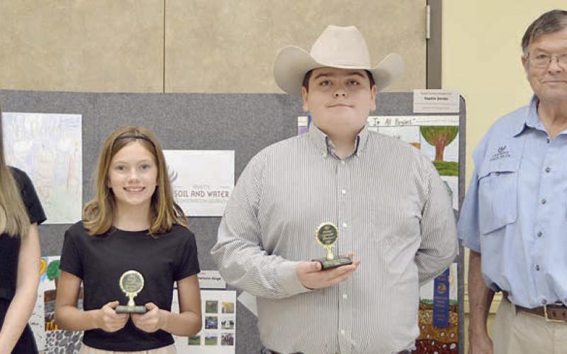 ESSAY CONTEST winners in the age 13 and under division were Bailey Brown (second from left) of Round Top-Carmine ISD and Rilan Karisch (second from right), home-schooled. Award sponsors were Prosperity Bank, represented by Ashley Firkins (left), and Carmine State Bank, represented by Roy Wied (right).