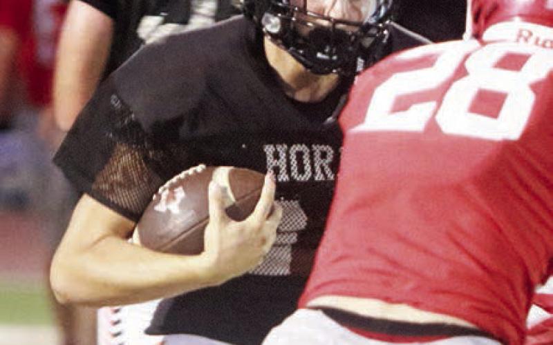 Mason Kunschick, who returns at running back, carries for 8 yards in the scrimmage last Thursday. Sticker Photo By Darrell Vyvjala