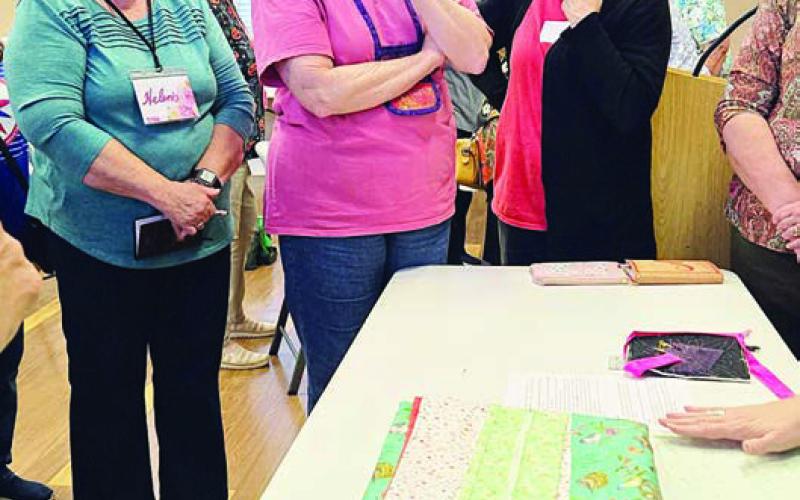 Photo at right – Watching a demonstration by Anita Todd (hands only) are Helen Muras, Debbie Huebel and Gay Dobbs.