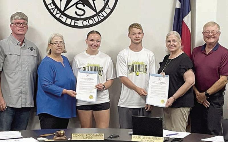 The Schulenburg City Council presents proclamations recognizing Schulenburg High School senior Mikayla Otto and sophomore Caden Herzik (center) for making the Class 2A state tennis tournament as a mixed doubles team. Shown with Otto and Herzik at Monday night’s meeting are: (from left) aldermen Greg Thomas and Frank Wick III, Mayor Connie Koopmann; and (from right) aldermen Clarence Ahlschlager, Roger Moellenberndt, and Kathy Kleiber. Sticker Photo By Darrell Vyvjala