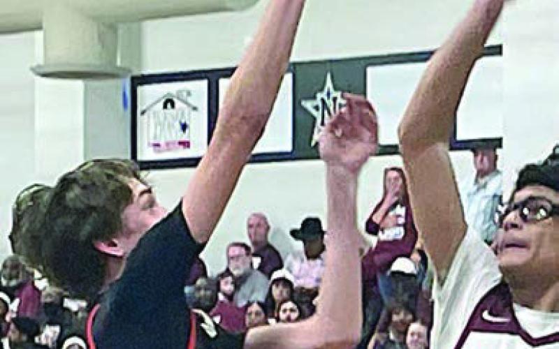 Adam Schramek scores in the lane over an Eagle in the fourth quarter. Sticker Photo By Darrell Vyvjala