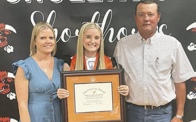 Madison Kunschick (center) received the valedictorian plaque with her parents, Michelle and David Kunschick alongside her, at the Senior Scholarship Banquet last week. Sticker Photo By Darrell Vyvjala