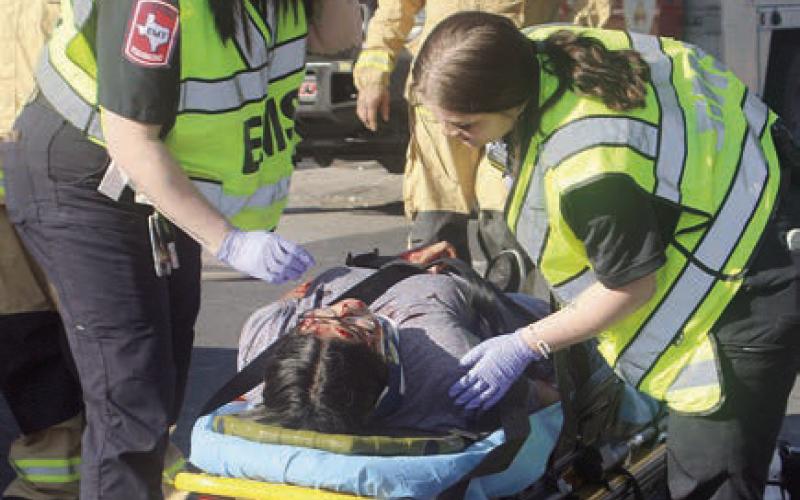 EMS personnel work on Yaritza Delgado before she had to be life-flighted. Sticker Photo By Darrell Vyvjala