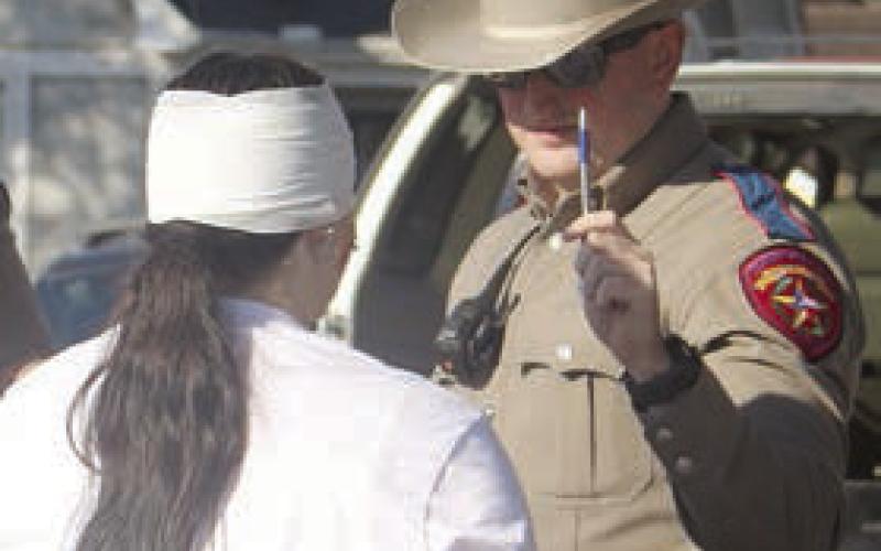 A DPS trooper gives Toree Bohlmann a field sobriety test. Sticker Photo By Darrell Vyvjala