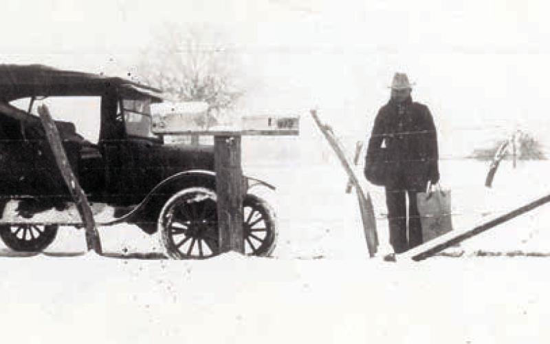 A mail carrier, possibly John Giese, is shown holding a mail bag and pouch after the Jan. 23, 1926, snowfall.