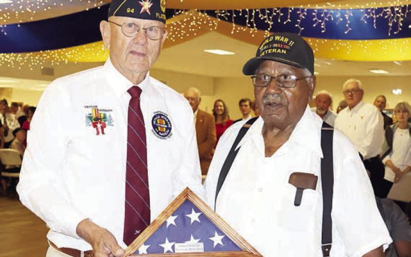The oldest veteran in attendance, 101-year-old World War II veteran B.J. Anderson of Smithville (right), is presented a folded flag by Flatonia American Legion Commander Danny Vyvjala (left). Photo By Melanie Berger / Courtesy of Flatonia Argus