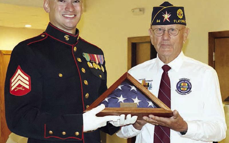 Flatonia American Legion Post 94 Commander Danny Vyvjala (right) presents a folded flag to the youngest veteran in attendance, 29-year-old Montana Olle of Schulenburg (left). Photo By Melanie Berger / Courtesy of Flatonia Argus