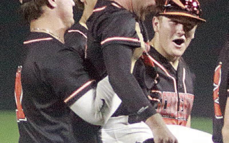 Winning pitcher Brycen Schramek get a hoist from Tyson Wagner as elated teammates surround them following the final out last Friday night. Sticker Photo By Darrell Vyvjala
