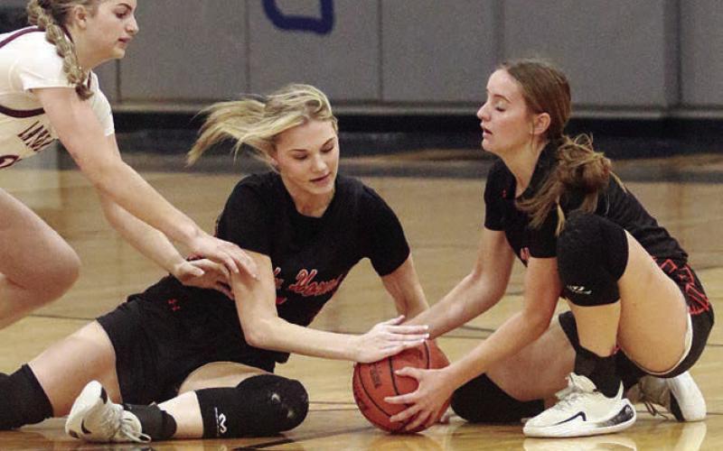 Alana Herzik (left) and Miranda Bonner combine for a take-away in the first quarter. Sticker Photo By Darrell Vyvjala