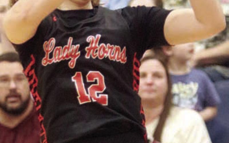 Grace Schramek gets the Lady Horns to within three points with a trey late in the game. Sticker Photo By Darrell Vyvjala