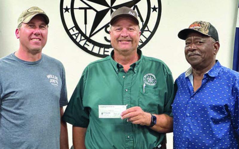 Schulenburg Economic Development Corporation President Paddy Magliolo (left) and Treasurer Ed Glass (right) present a $220,000 check to City Operations Manager Darryl Moeller. The funds will go toward paving at the Civic Center as well as on Matula, Kueper, and Avenue and B ($70,000) along with sewer line relocation and line replacement on College Street ($150,000.