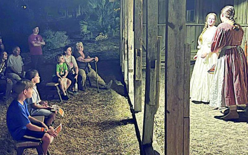 A captivated aud ience watches two Fayette County Community Theatre actors perform a scene during a Memories of Monument Hill tour in 2024.