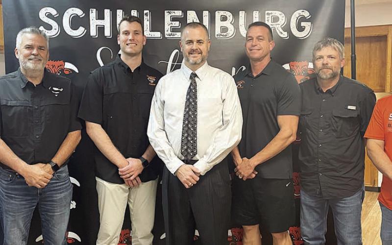 Welcoming Dr. Jerrod Barton (center) after his hiring as the new secondary principal last Wednesday are: (from left) Schulenburg ISD Board of Trustees President Mike Zweschper, Superintendent Lee Hafley, Trustee Hale Hentges; (from right) trustees Jarrod Schramek, Joel Blansitt, and Shannon Hollas. Sticker Photo By Darrell Vyvjala