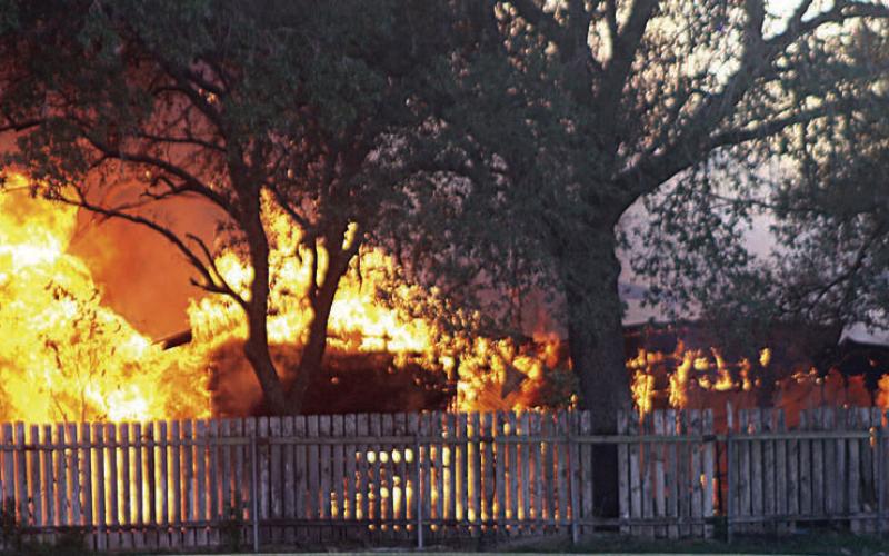 Flames totally engulf the outbuilding at 507 Bucek St. Sticker Photo By Darrell Vyvjala
