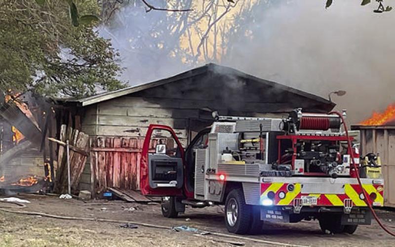 SVFD personnel get the structure fire knocked down but material in a rolloff container continues to burn. Sticker Photo By Darrell Vyvjala