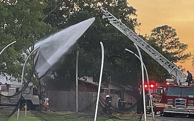 Below: Ladder 4 provides the deluge of water to put out all of the remaining embers. Sticker Photo By Darrell Vyvjala