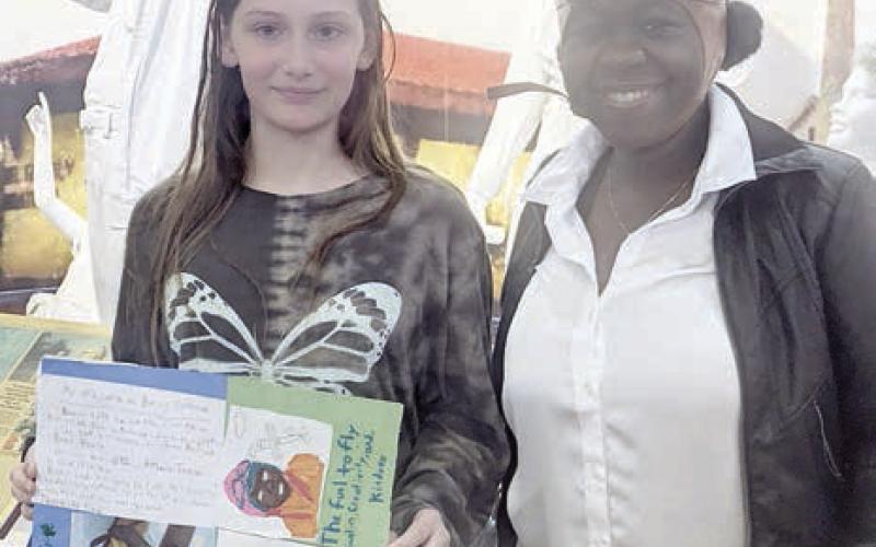 Holidng a poster titled ‘My Information on Bessie Coleman is Nevaeh Motley (left), shown with Rebecca Powe (right).