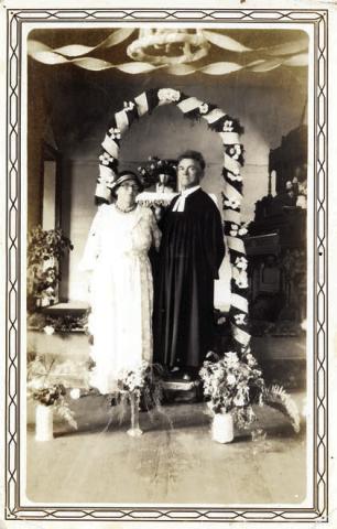 Minna and Rev. Carl Baer standing under a decorated arch in 1935. – Courtesy of Fayette Heritage Museum &amp; Archives