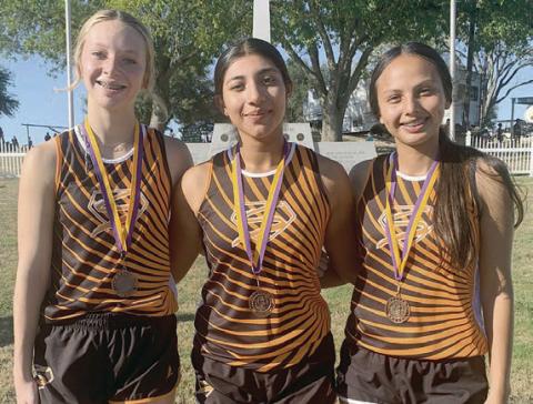 Earning medals for the Lady Horns at the Shiner cross country meet were (from left) Michaela Kollmann, Ruby Rodriguez, and Yasmin Cortez.