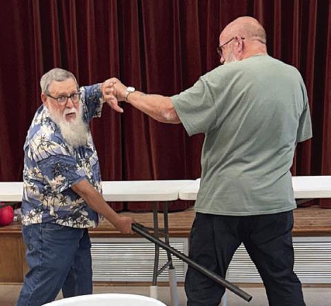 Demonstrating self-defense techniques to members in Weimar was David MaCall (left). This was just a taste of the program he will put on in the near future. David Wyman (right) was kind enough to help with the demonstration.