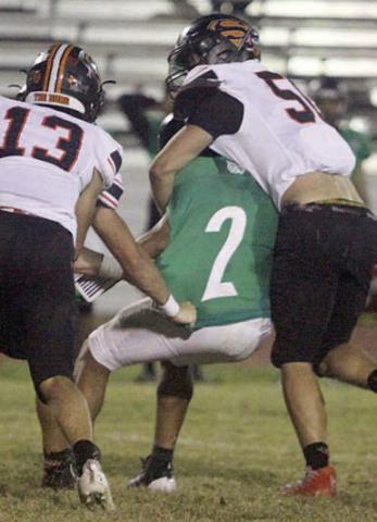 Preston Kahn and Cooper Demel (No. 13) drop Kennylee Flood for a loss of 2 in the first quarter. Sticker Photo By Darrell Vyvjala