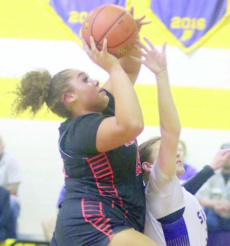 Arianna Vincent goes up over a Lady Comanche to score in the first quarter. Sticker Photo By Darrell Vyvjala