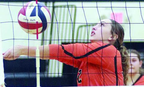 Grace Schramek saves a ball near the net in set one. Sticker Photo By Darrell Vyvjala