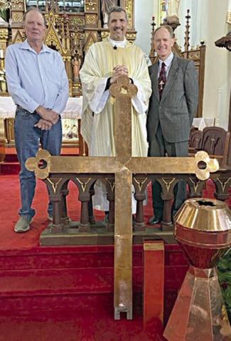 As part of the new steeple roof installation at Nativity of the Blessed Virgin Mary Catholic Church in High Hill, a new 7-foot cross will be installed atop the steeple. The existing cross was not reparable so a new stainless steel cross clad in copper was manufactured and donated by Dennis Venghaus-Schulenburg Sheet Metal. Shown are (from left are Dennis Venghaus, Fr. Luke Prihoda and Forrest Lauher, church maintenance coordinator.