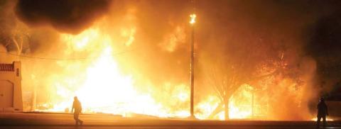 Fire fully engulfs the two homes to the east of Schulenburg Liquor Store near the intersection of Highway 90 and Highway 77. Sticker Photo By Darrell Vyvjala