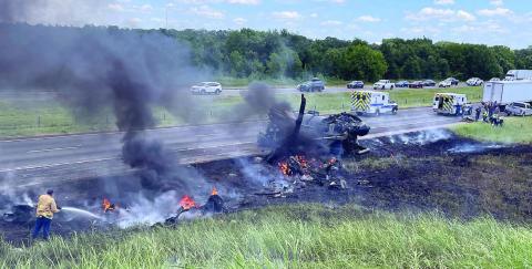 A Schulenburg VFD firefighter (bottom, left) works to extinguish the remaining flames while Fayette County EMS personnel (top, right) work to try to save the victim of an accident on Interstate 10 this past Saturday.