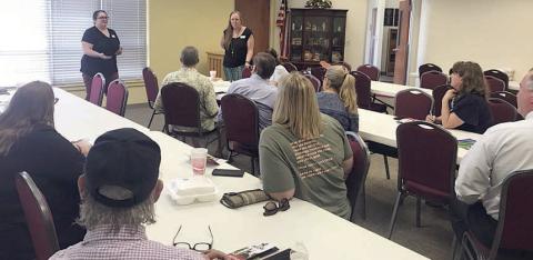 Lions Club members heard from Susie Shank (standing in back at right) and Sarah Nickel (standing in back at left) who spoke about the Alliance for College &amp; Career Student Success (ACCSS),