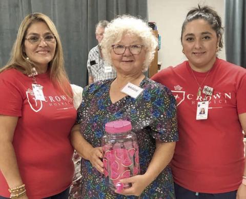 Bingo callers from Crown Hospice of Victoria – Addy Priour (left) and Mary Rubio (right) – are shown with blackout winner Margaret Lozarro (center).