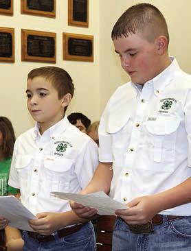 Gage Smrkovsky (left) and Abraham McBride present the report of the Schulenburg 4-H activities over the past year to the Commissioners Court. Photo By Melanie Berger / Courtesy of Flatonia Argus