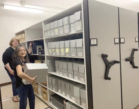 Organizing the new shelv ing at the Fayette Heritage Museum &amp; Archives in La Grange are archivists Maria Rocha (front) and Rox Ann Johnson.
