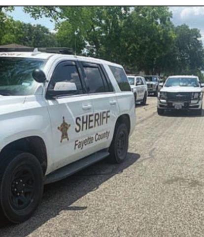 Law enforcement officers converge on a residence on Baumgarten Street Friday to execute a search warrant.