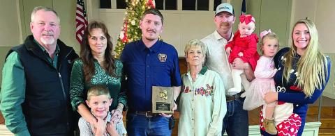 The SVFD OUTSTANDING SERVICE AWARD for 2025 went to Dylan Schilhab (center, holding plaque). He made the highest percentage of calls, meetings and drills at 89 percent. The award is sponsored annually by the family of the late Chief Roland Proske and his wife Pat Proske. Making the presentation were (from left) Jeff and Terry Proske, Will Proske, (continuing aftter Schilhab) Pat Proske, Doran Proske holding Clara, and Kelsey Proske holding Lace. . Sticker Photo By Darrell Vyvjala