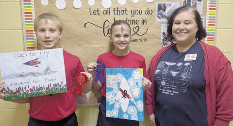 ST. Rose winners – Addison Ann Zita Johnson (center), first place; and Brennen Berger (left), runner-up. Representing Stanzel Model Aircraft Museum is director Cynthia Fogleman (right).