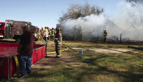 Smoke billows from the barn north of town as SVFD personnel use a “dump tank” (left) to keep water flowing as they put out the fire last Friday. Sticker Photo By Darrell Vyvjala