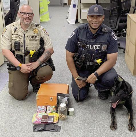 Sheriff’s Department Deputy Josh Jones (left) and Schulenburg Police Department Officer Byron Powe with his canine partner, Semper, are shown with the items found after a traffic stop last Wednesday on Highway 71.