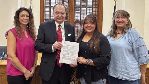 The Resolution regarding wind turbines, signed at the Fayette County Commissioners Court meeting on Aug. 8, was presented by County Judge Dan Mueller (second from left) and Court Administrator Cassie Austin (left) and accepted by T.J. “TJ Mac” McCleney (second from right) of Swiss Alp and Wendy Syrinek (right) of Middle Creek.