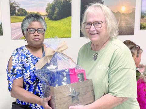 Talented artist and member Janice Collins (left) assembled this gift basket featuring a Texas-shaped mosaic that she created, a bottle of Texas Crown Whiskey and two commemorative glasses. A drawing was held, won by Carolyn Foster (right). The drawing raised $740, with all the funds going to the building capital campaign.