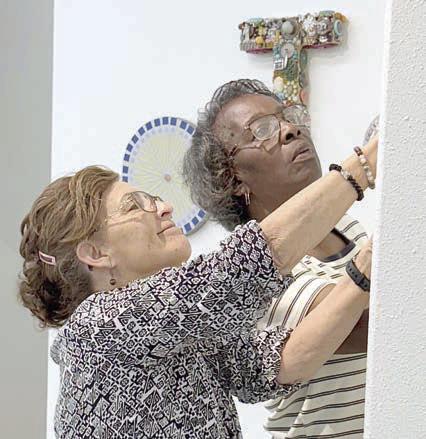 Wor king diligently to hang items for the Ageless Artistry show were (from left) Martha Beckmann and Deborah Jones, one of several teams of artists. The reception was held on Saturday, April 12 and the exhibit will remain open until May 9 at 1203 Kessler Ave. in Schulenburg.